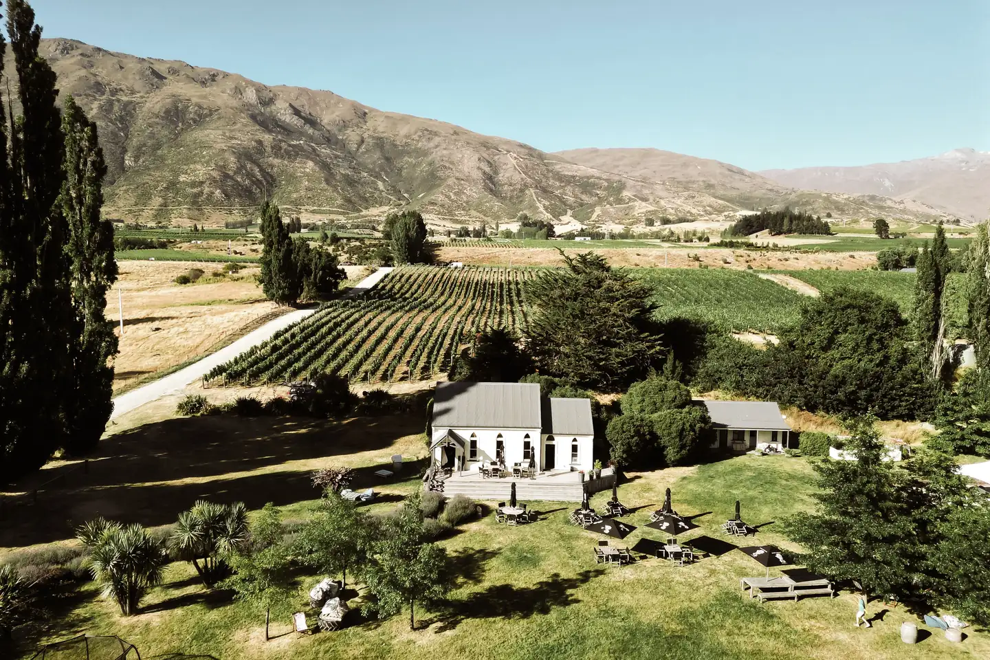 Looking down on the little white church with umbrella tables on its lawn, rows of chardonnay climbing the slope behind it to the Gibbston hills